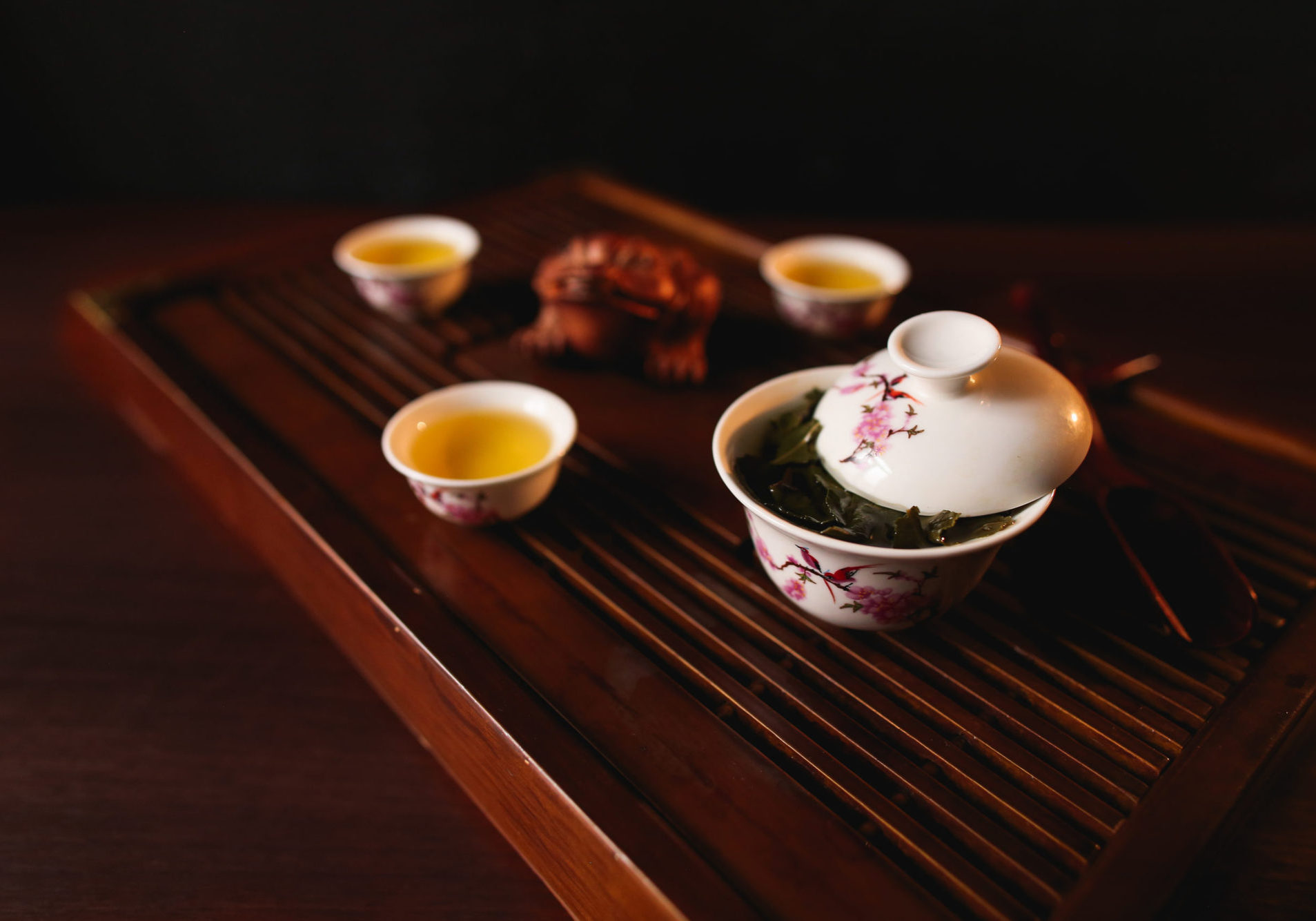 The Traditional Chinese tea ceremony. Porcelain gaiwan and three cups on a tea desk chaban.